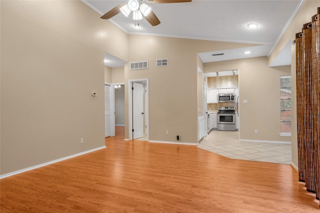 unfurnished living room featuring ornamental molding, light wood-type flooring, and visible vents