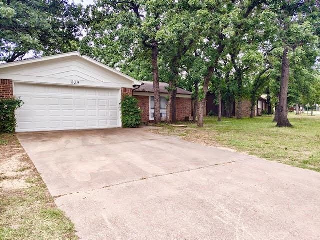 829 Lake Crest Pkwy, Azle, TX 76020 - ranch-style house featuring brick siding, an attached garage, driveway, and a front lawn