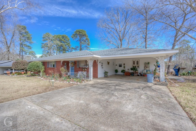 ranch-style home featuring an attached carport, covered porch, brick siding, and driveway