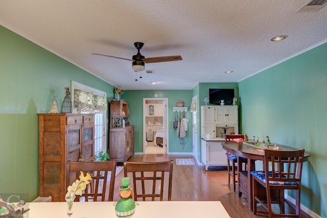 1106 Bryan St, Minden, LA 71055 - dining space with visible vents, crown molding, a textured ceiling, and wood finished floors