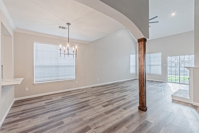 interior space featuring arched walkways, an inviting chandelier, baseboards, and wood finished floors