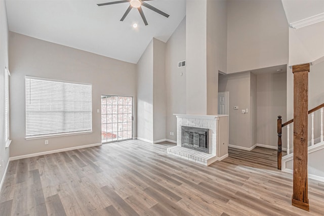 unfurnished living room featuring visible vents, baseboards, stairs, light wood-type flooring, and a fireplace