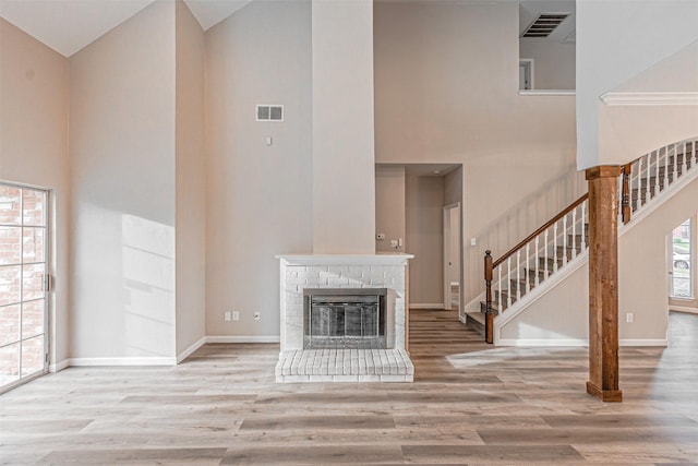 unfurnished living room featuring stairs, visible vents, and wood finished floors