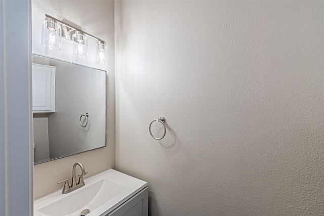 bathroom featuring a textured wall and vanity