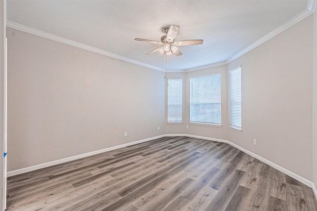 empty room with baseboards, ceiling fan, wood finished floors, and crown molding