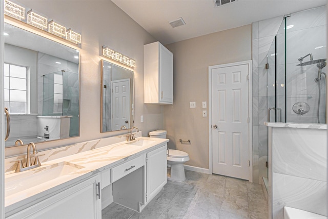 full bath featuring a stall shower, a sink, and toilet