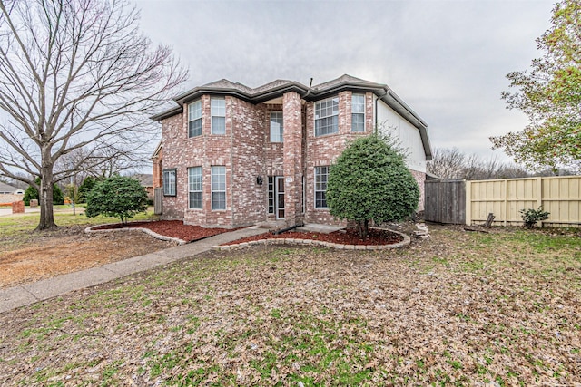 view of front of home with fence and brick siding