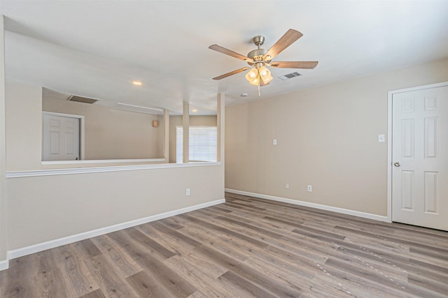 unfurnished room featuring baseboards, visible vents, and wood finished floors