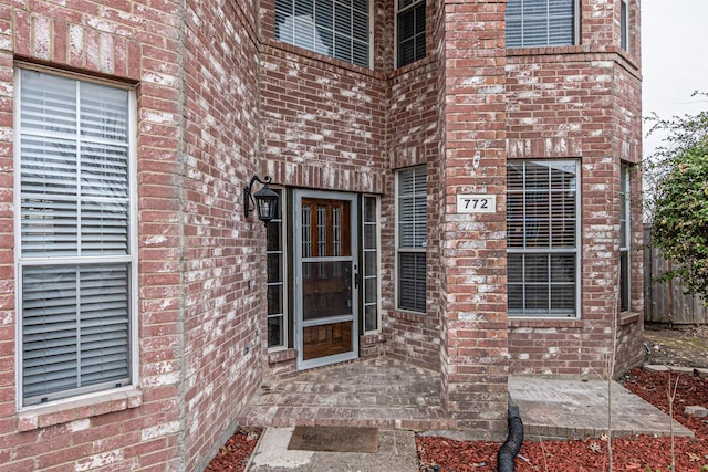 doorway to property featuring brick siding