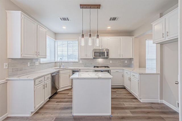 kitchen with appliances with stainless steel finishes, visible vents, and white cabinetry