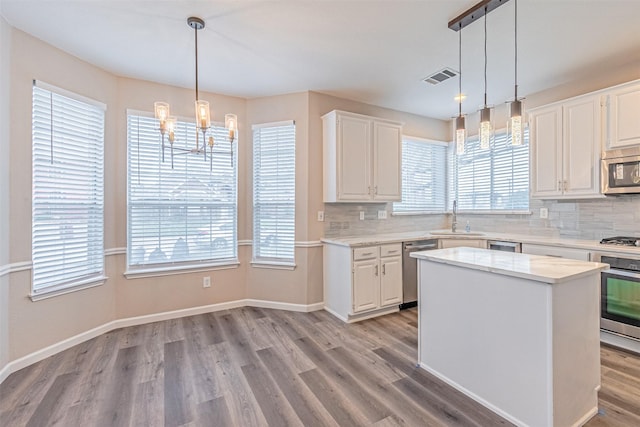 kitchen with light wood-style flooring, visible vents, stainless steel appliances, and a sink