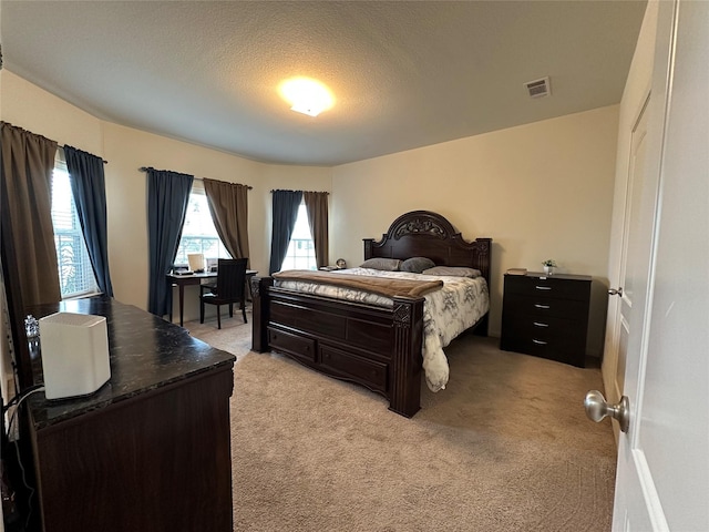 bedroom with visible vents, a textured ceiling, and light colored carpet