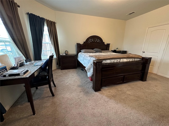 bedroom with visible vents and light carpet