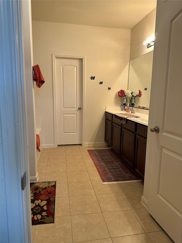 full bath with vanity, baseboards, and tile patterned floors