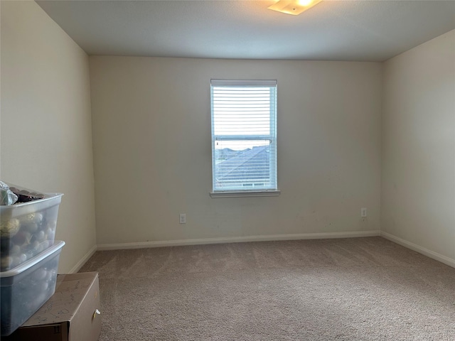 carpeted empty room with baseboards