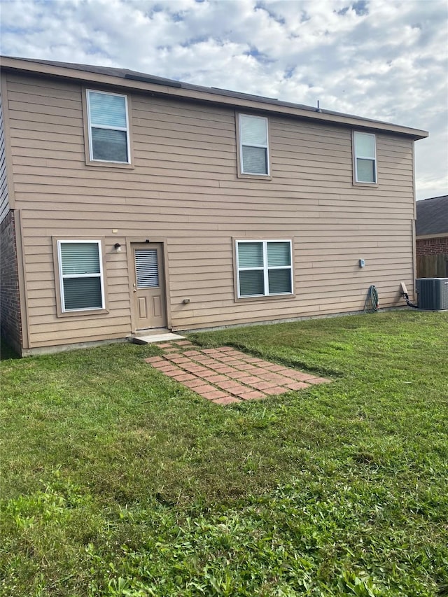 back of house featuring a lawn and central AC unit