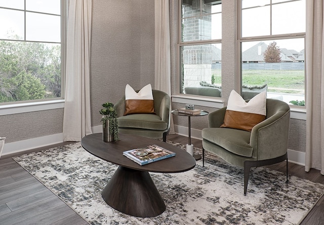 living area featuring baseboards, wood finished floors, a wealth of natural light, and wallpapered walls