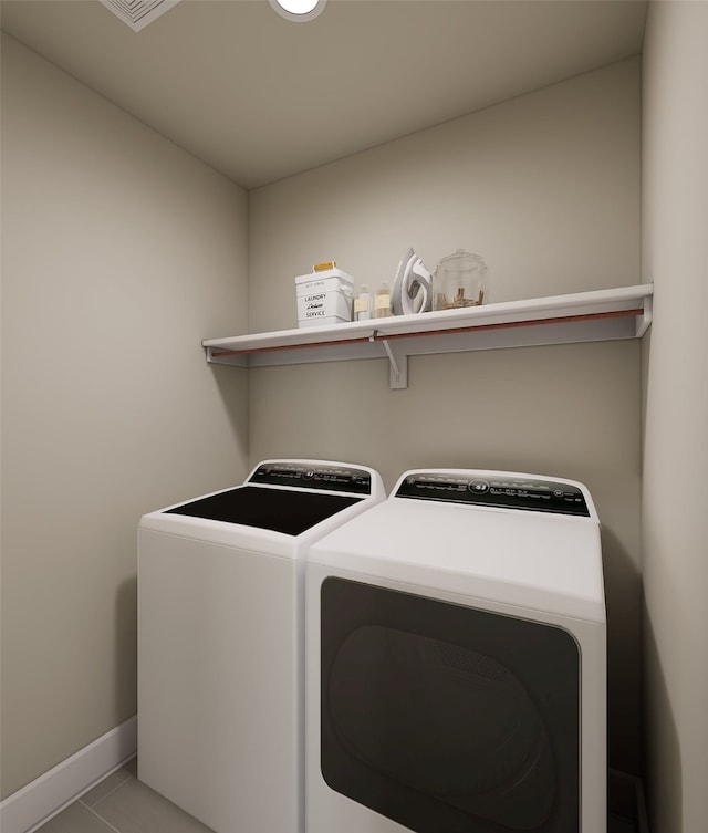 laundry area with baseboards, laundry area, washer and clothes dryer, and tile patterned floors