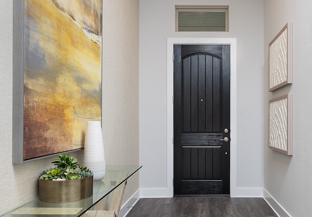 interior space featuring baseboards and dark wood finished floors