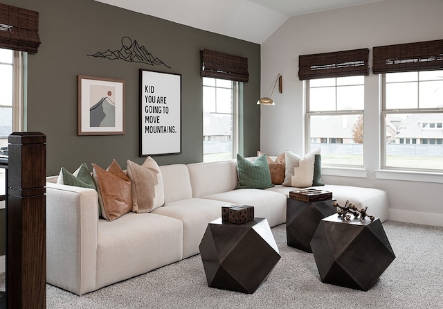 living room with lofted ceiling, carpet floors, baseboards, and a healthy amount of sunlight