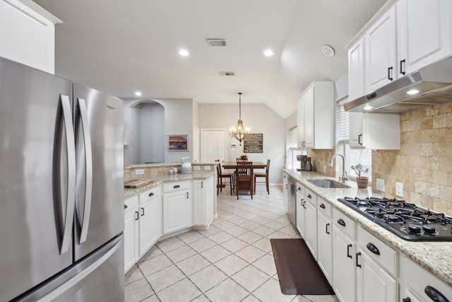 kitchen with visible vents, appliances with stainless steel finishes, a sink, under cabinet range hood, and backsplash