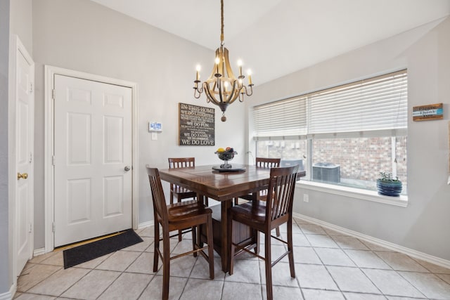 dining area with light tile patterned floors, baseboards, a chandelier, and vaulted ceiling