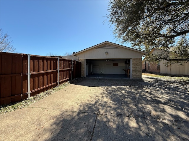 garage featuring driveway and fence