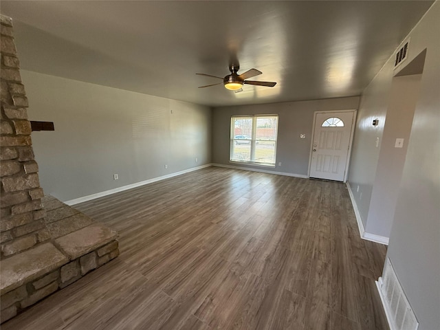 unfurnished living room featuring visible vents, a ceiling fan, and dark wood-style flooring