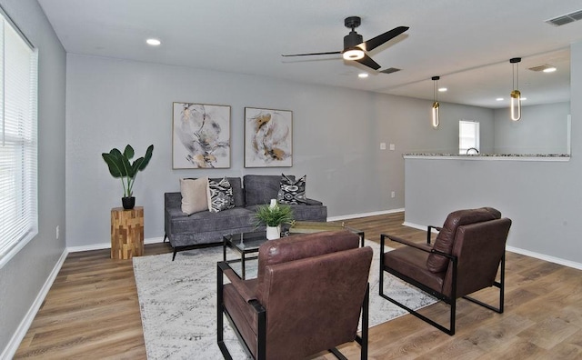 living area with baseboards, visible vents, wood finished floors, and recessed lighting