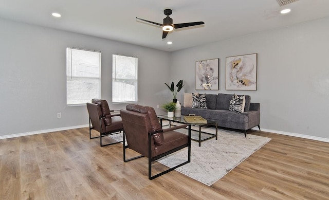 living room with light wood-style floors, baseboards, a ceiling fan, and recessed lighting