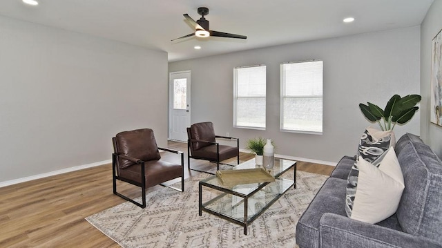 living area featuring a ceiling fan, baseboards, wood finished floors, and recessed lighting