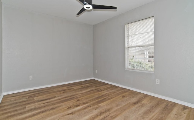 spare room with ceiling fan, baseboards, and wood finished floors