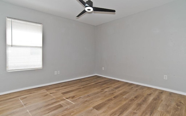 spare room featuring ceiling fan, baseboards, and wood finished floors