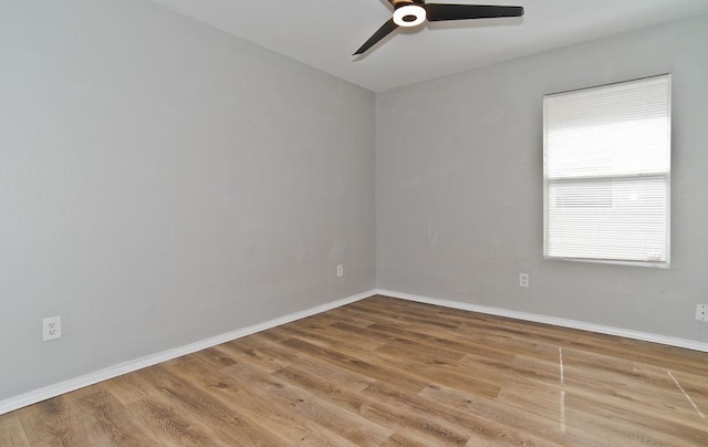 empty room featuring wood finished floors, a ceiling fan, and baseboards