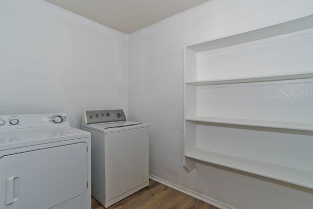 washroom with washing machine and dryer, laundry area, and wood finished floors