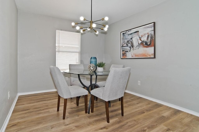 dining space featuring an inviting chandelier, baseboards, and wood finished floors