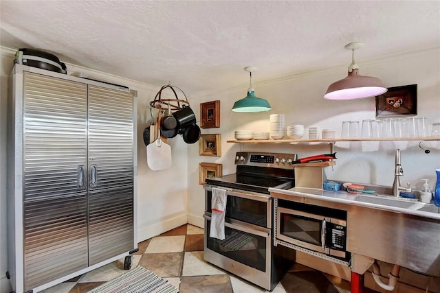 kitchen with a textured ceiling, baseboards, stainless steel appliances, and crown molding