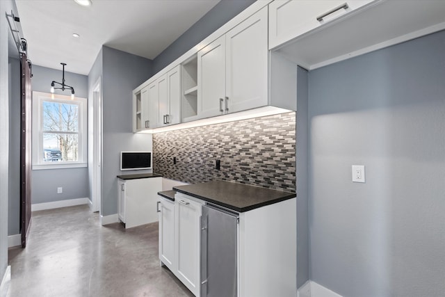 kitchen with baseboards, decorative backsplash, dark countertops, finished concrete floors, and open shelves