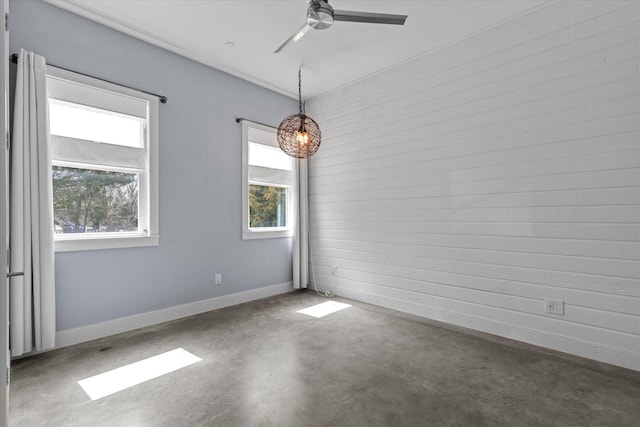 spare room with concrete flooring, ceiling fan, and baseboards