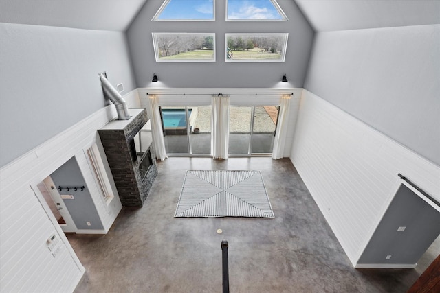 unfurnished living room with lofted ceiling and finished concrete flooring