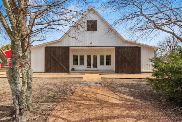 rear view of house featuring a barn, an outbuilding, and french doors