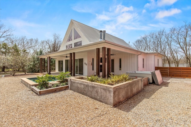 back of house with board and batten siding, a patio area, fence, and ceiling fan