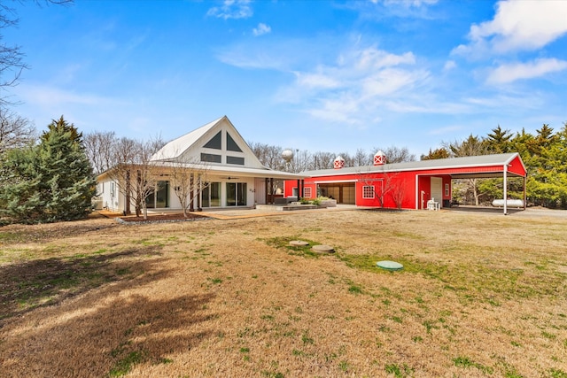 view of front of home with a patio, a ceiling fan, driveway, a carport, and a front yard