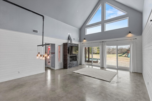 unfurnished living room with high vaulted ceiling, a fireplace, visible vents, and finished concrete floors