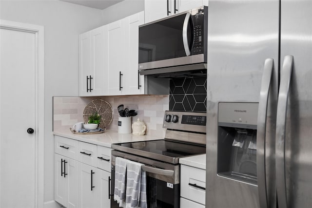 kitchen with appliances with stainless steel finishes, light countertops, backsplash, and white cabinetry