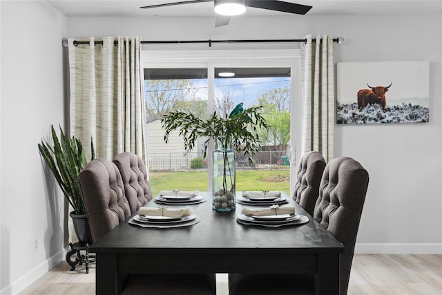 dining area with a ceiling fan, baseboards, and light wood finished floors