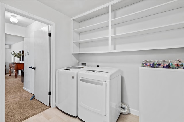 laundry area with light wood-type flooring, laundry area, baseboards, and washer and dryer