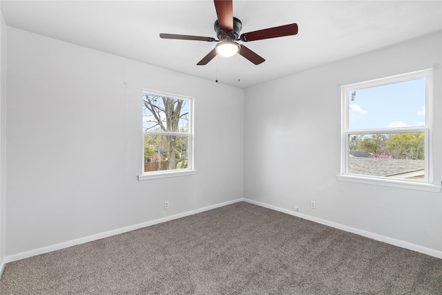 carpeted spare room with ceiling fan and baseboards