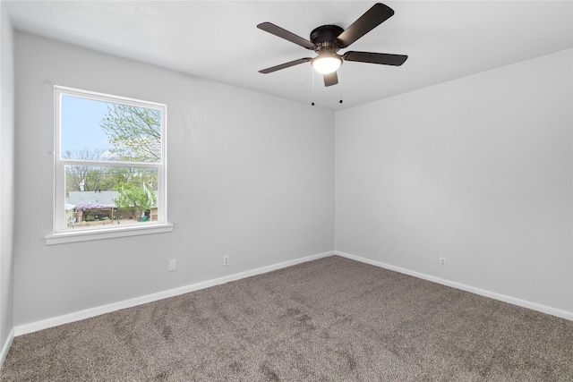 carpeted empty room with ceiling fan and baseboards