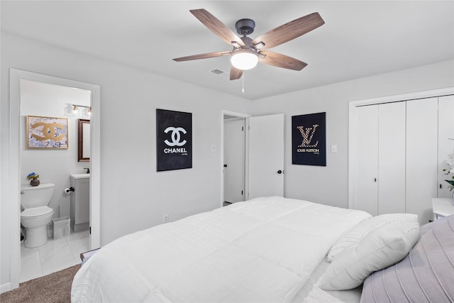 carpeted bedroom featuring a closet, visible vents, ceiling fan, and ensuite bathroom